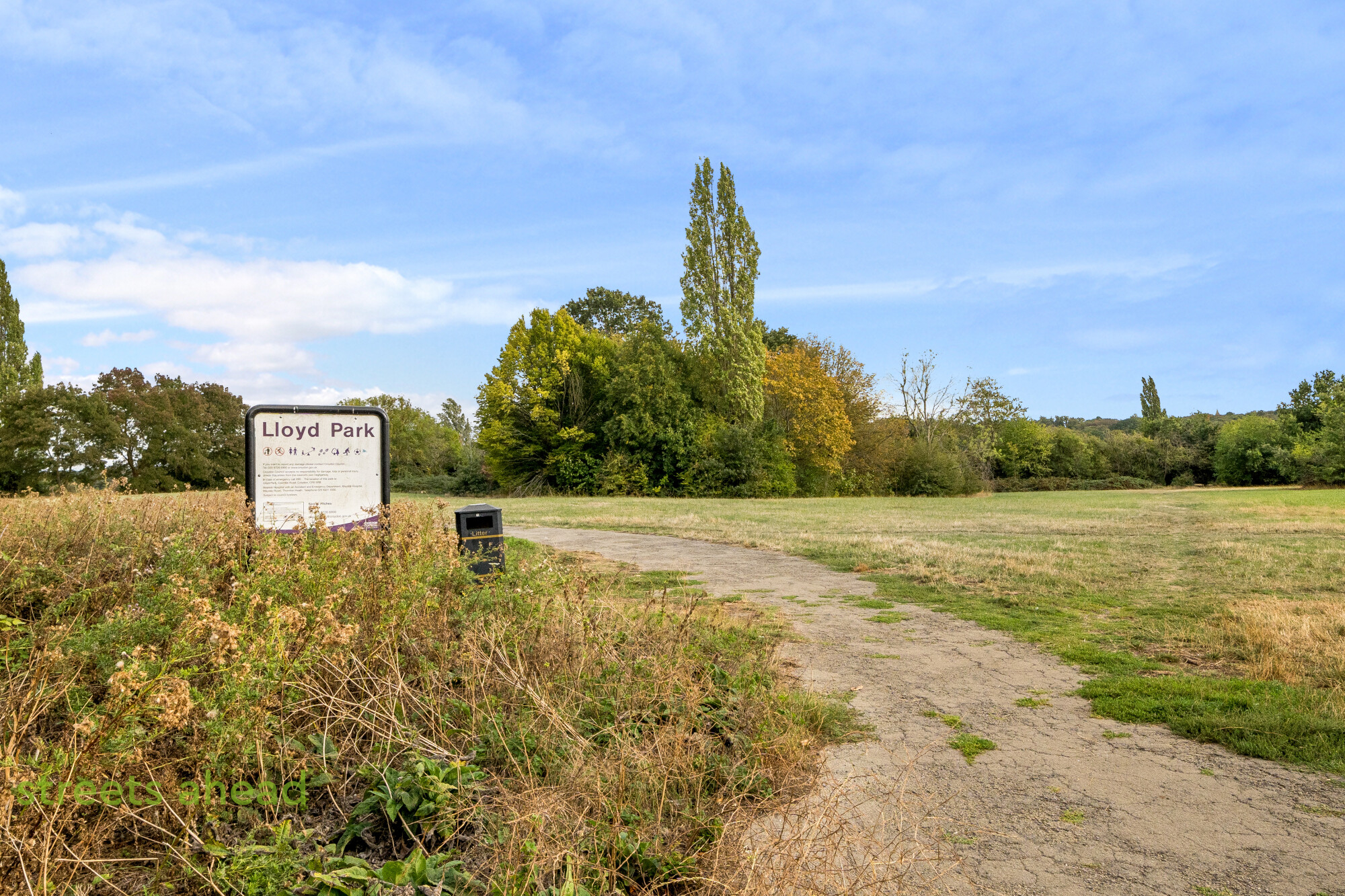Lloyd Park in Croydon Open grassland and trees beside the Lloyd Park sign in Croydon
