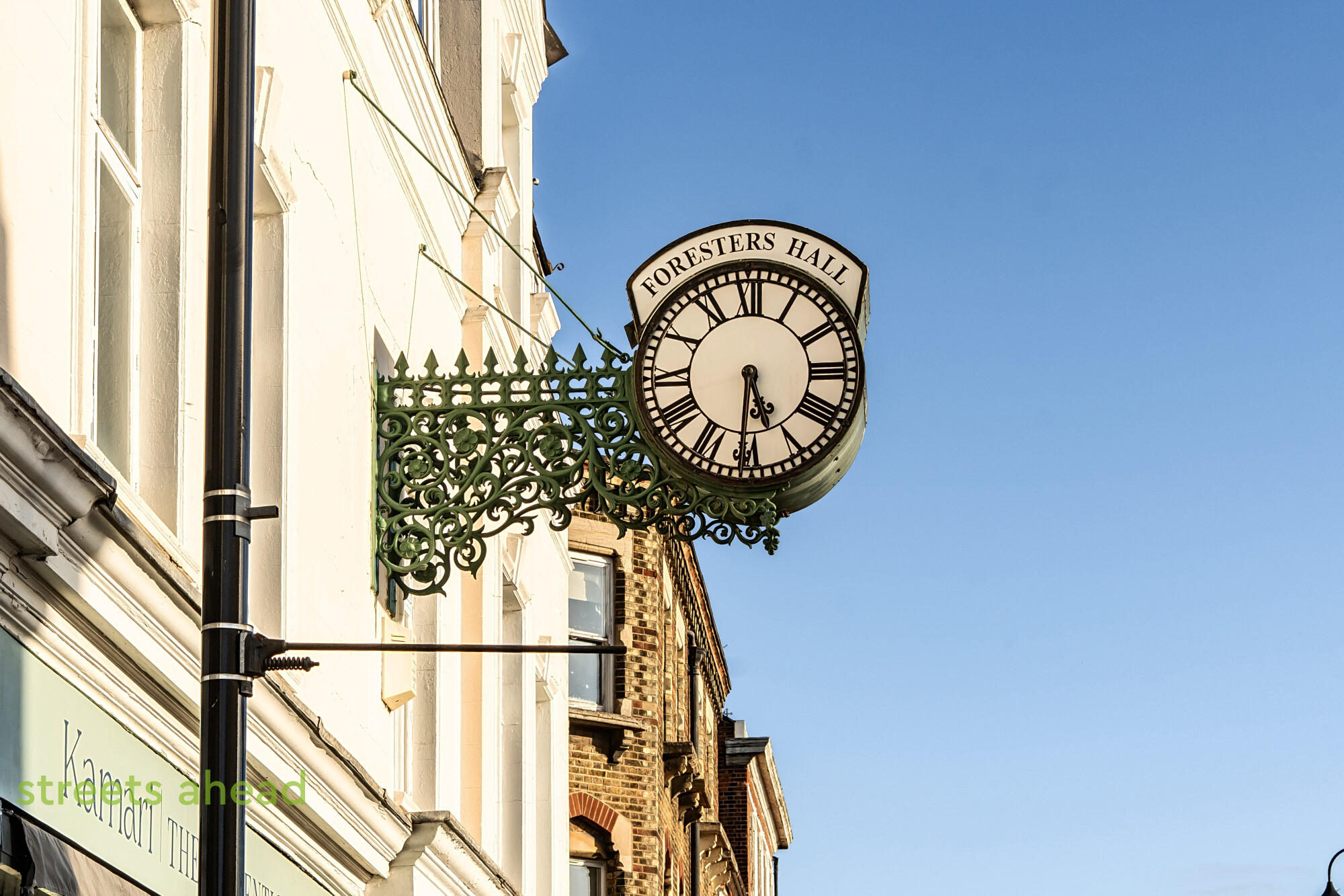 Bracket clock mounted on a building on Westow Street in Crystal Palace